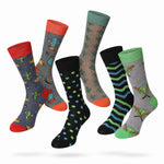 Six pairs of patterned crew socks floating against a light gray background. The designs include cactus prints on gray and navy socks, a teal pattern on beige, blue polka dots on black, green and blue stripes on black, and green accents on gray with cartoon characters.