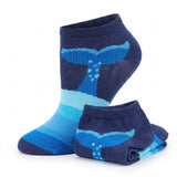 A pair of low-cut ankle socks in shades of navy, blue, and light blue, featuring a whale tail and bubble pattern, shown on a white background.