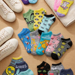 Colorful socks with various designs on a wooden surface with sneakers.