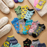 Colorful socks with various designs on a wooden surface with sneakers.