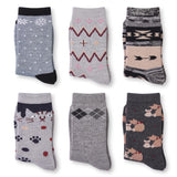 Six pairs of folded crew socks arranged in a 2x3 grid on a white background. The socks feature various patterns including snowflakes, zigzags, argyle, paw prints, and cartoon dogs in shades of gray, black, beige, and pink.