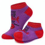 A pair of low-cut ankle socks in purple and red with a graphic design. The design features the word 'COFFEE' repeated in black, stylized red script reading 'black coffee', and a graphic of red lips with a black line drawing.