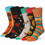 Six pairs of novelty crew socks arranged in a fan shape on a white background. The socks feature colorful cartoon food and character designs, including a hot dog, tomatoes, burgers, and a character with 'DAINTY' written on the foot.