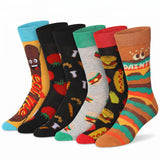Six pairs of novelty crew socks arranged in a fan shape on a white background. The socks feature colorful cartoon food and character designs, including a hot dog, tomatoes, burgers, and a character with 'DAINTY' written on the foot.