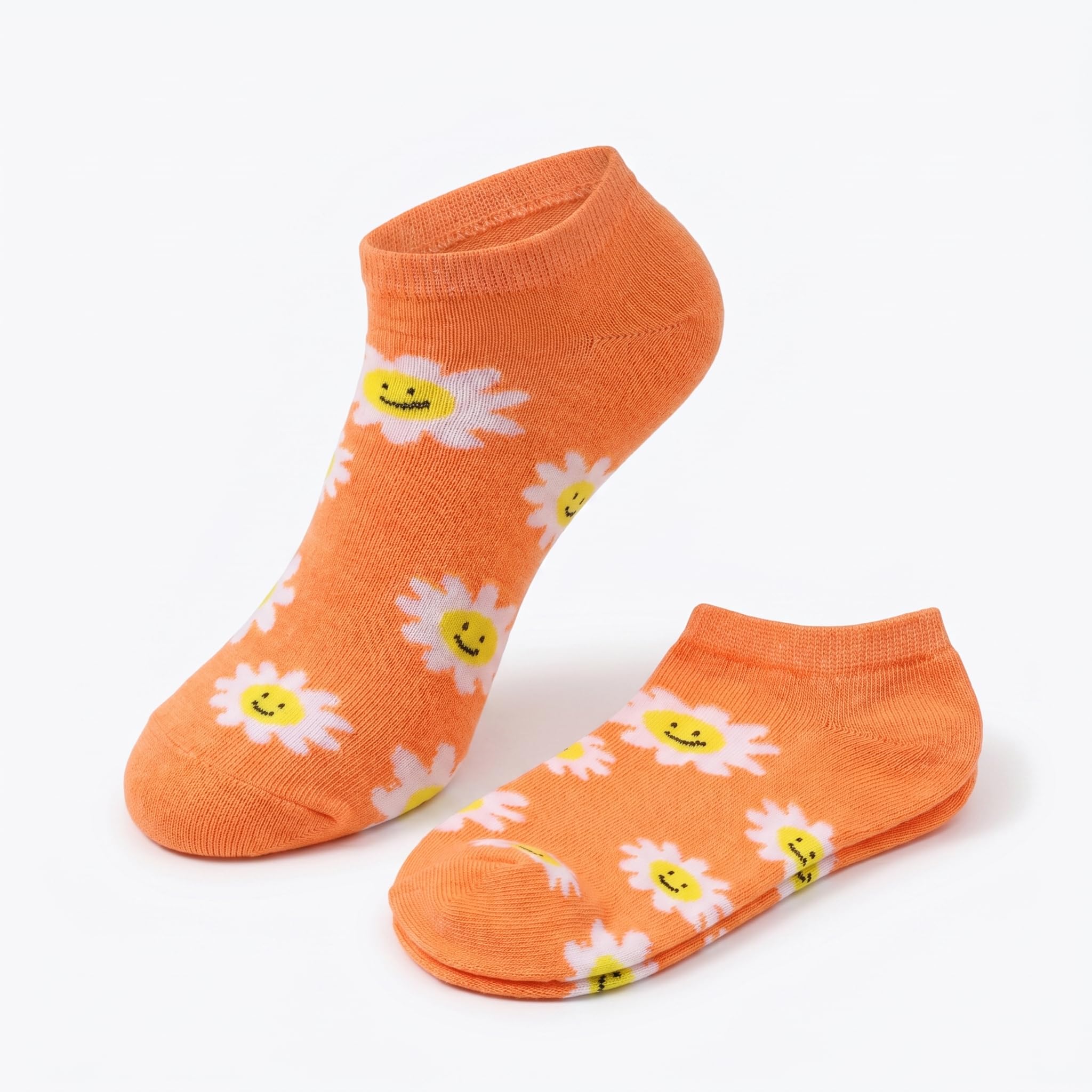 A pair of low-cut ankle socks in a vibrant orange color, decorated with a pattern of white daisies that have yellow centers and small smiling faces, displayed on a clean white background.