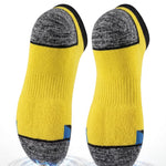 A pair of yellow and gray athletic socks shown floating on a white background with marketing text at the top reading 'Cushioned Sole Comfort' and 'Soft impact protection every step.' The socks have a bright yellow main body, heather gray heel and toe sections, black trim, and small blue accent tabs near the foot.