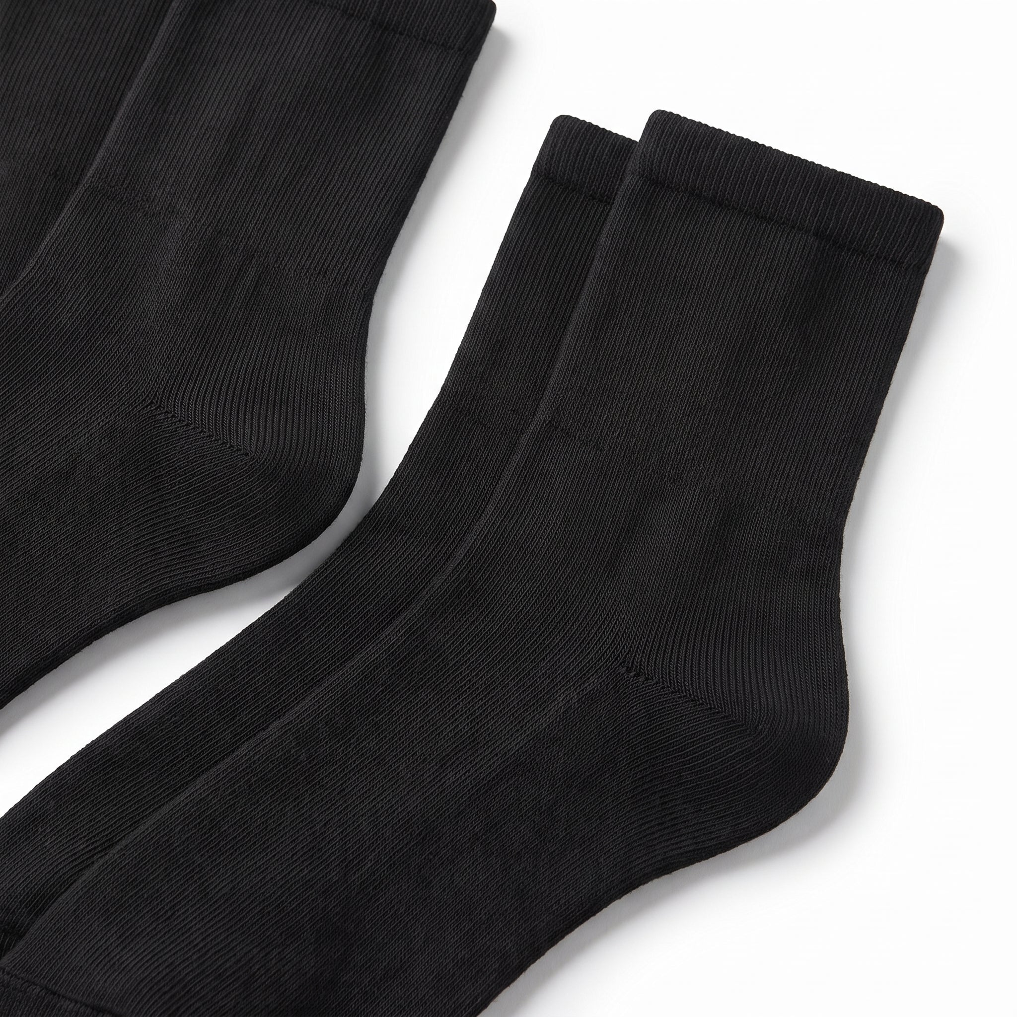 Three pairs of black ribbed crew socks arranged diagonally on a clean white background.