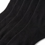 A close-up of black ribbed knit socks showing the texture and fold pattern against a white background.