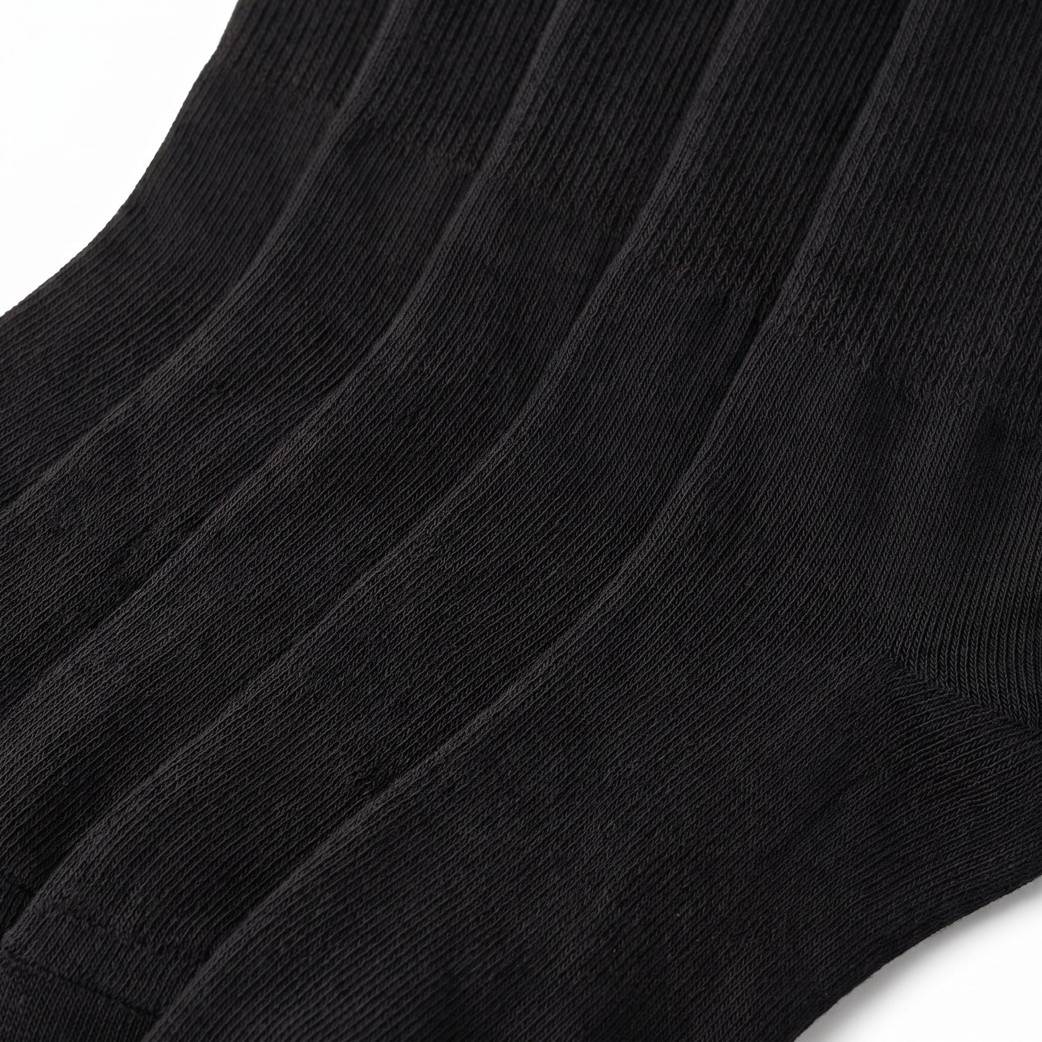 A close-up of black ribbed knit socks showing the texture and fold pattern against a white background.