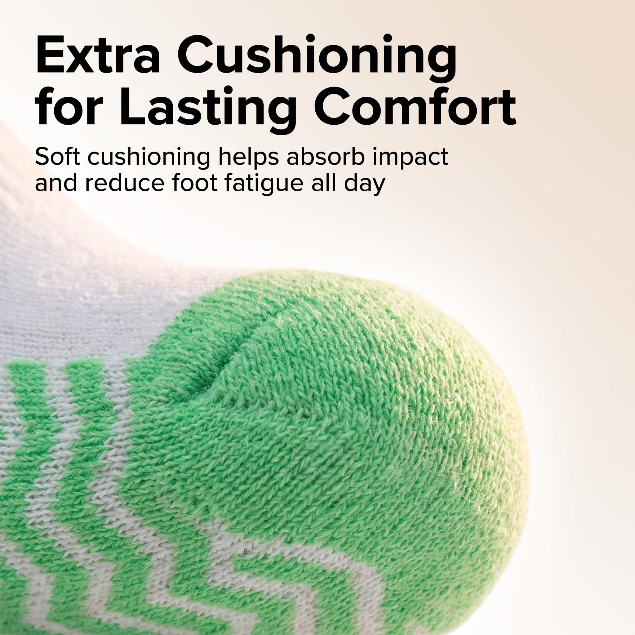 Close-up of a green and white knit sock with text reading 'Extra Cushioning for Lasting Comfort' and 'Soft cushioning helps absorb impact and reduce foot fatigue all day.'.