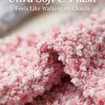 Close-up of pink and white fluffy fabric with text 'Ultra Soft & Plush Feels Like Walking on Clouds'.