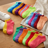 Colorful socks arranged on a wooden surface with a white shoe.