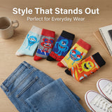 Colorful cartoon socks on a wooden surface with jeans and a cup.