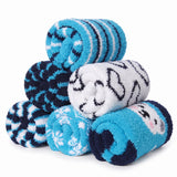 A stack of five plush, rolled bath towels in various patterns and colors, including blue and white stripes, navy and white geometric designs, and a blue towel with a cartoon face, set against a plain white background.