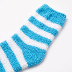 A close-up of a fuzzy, textured sock with horizontal stripes in bright blue and white, shown on a clean white background.