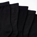Five black ribbed knit socks fanned out against a plain white background.