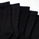 Five black ribbed knit socks fanned out against a plain white background.