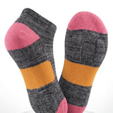 Pair of socks with gray, pink, and orange design on a white background
