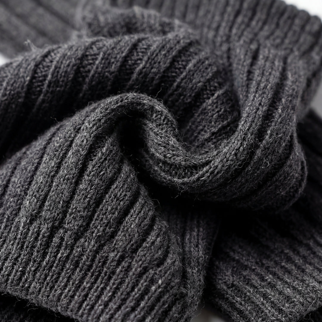 Stack of dark gray ribbed socks on a white background