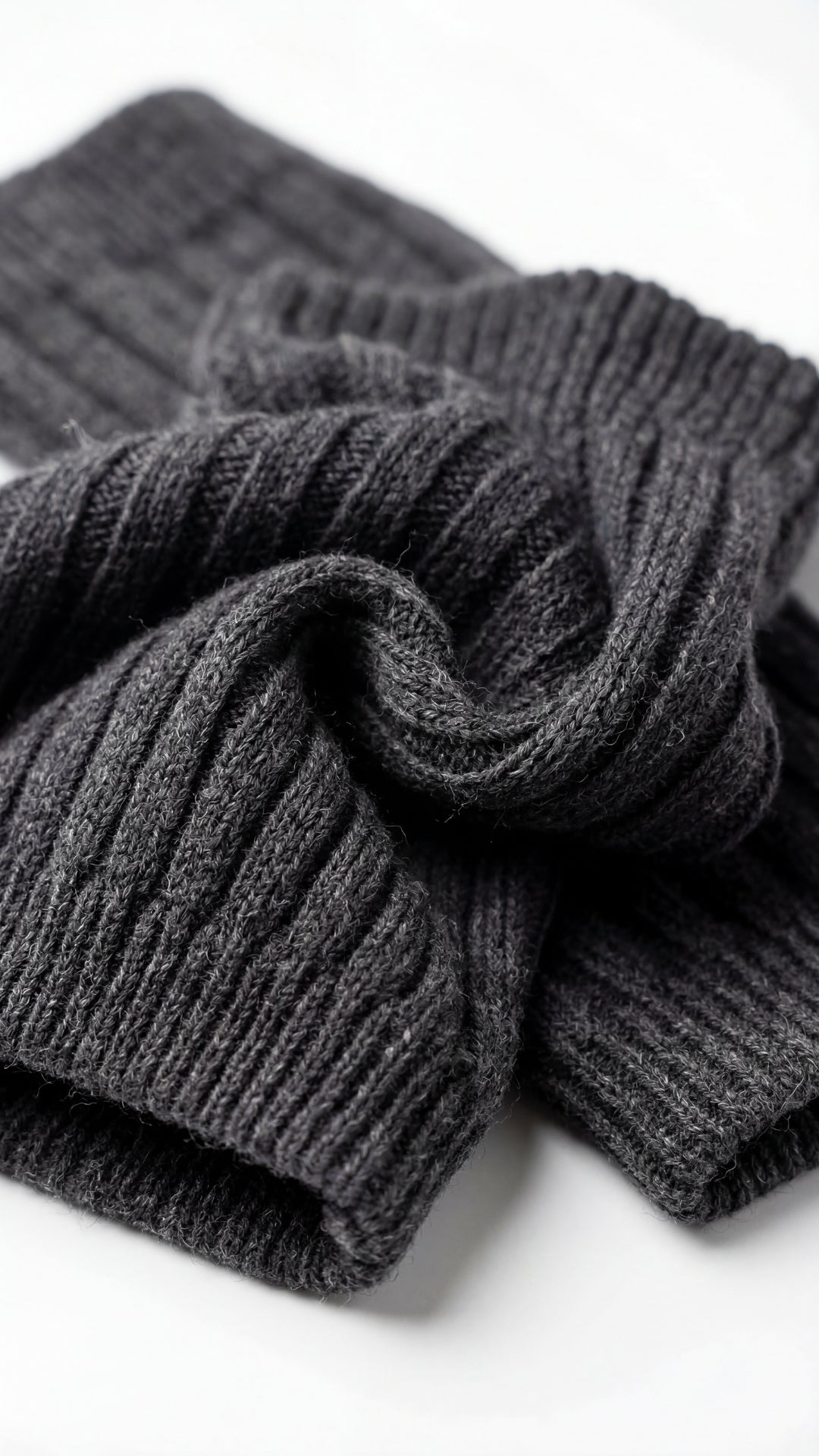Stack of dark gray ribbed socks on a white background