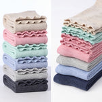 Stacks of folded ruffled fabric in various colors on a white background