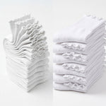 Stacks of white folded socks on a light gray background