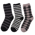 Three fuzzy crew socks shown on a plain white background: one dark gray and black striped, one black and white striped, and one taupe and black checkered pattern.