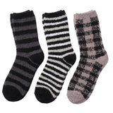 Three fuzzy crew socks shown on a plain white background: one dark gray and black striped, one black and white striped, and one taupe and black checkered pattern.