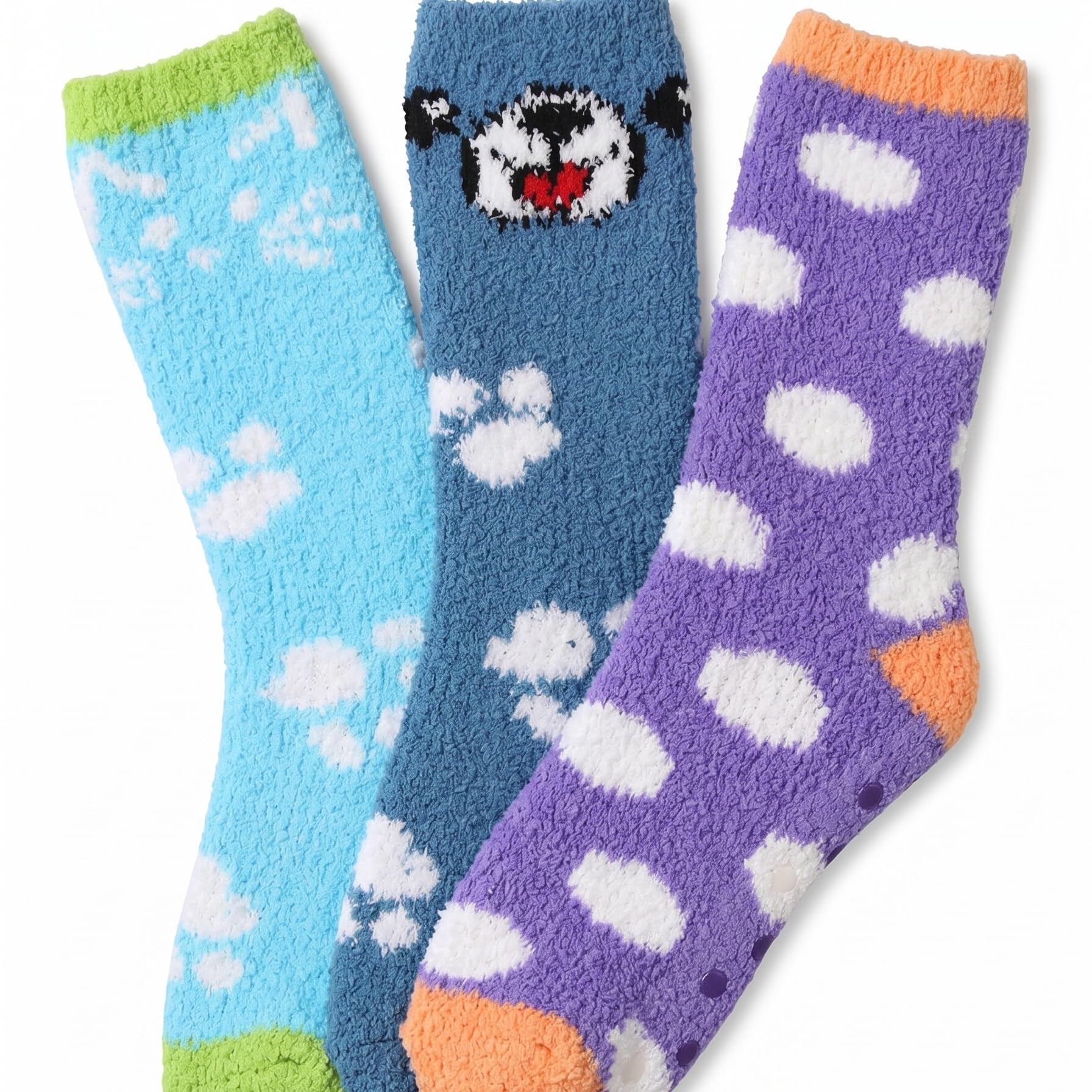Three fuzzy socks arranged together on a white background: a light blue sock with white paw prints and a green toe/heel, a medium blue sock with a black-and-white bear face and white paw prints, and a purple sock with white polka dots and an orange toe/heel.