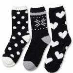 Three pairs of black socks with white patterns on a white background