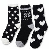 Three pairs of black socks with white patterns on a white background
