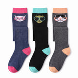Three pairs of crew socks displayed side by side on a white background. The left pair is navy blue with a pink cuff, pink heel, and pink toe, featuring a cat face wearing pink glasses.