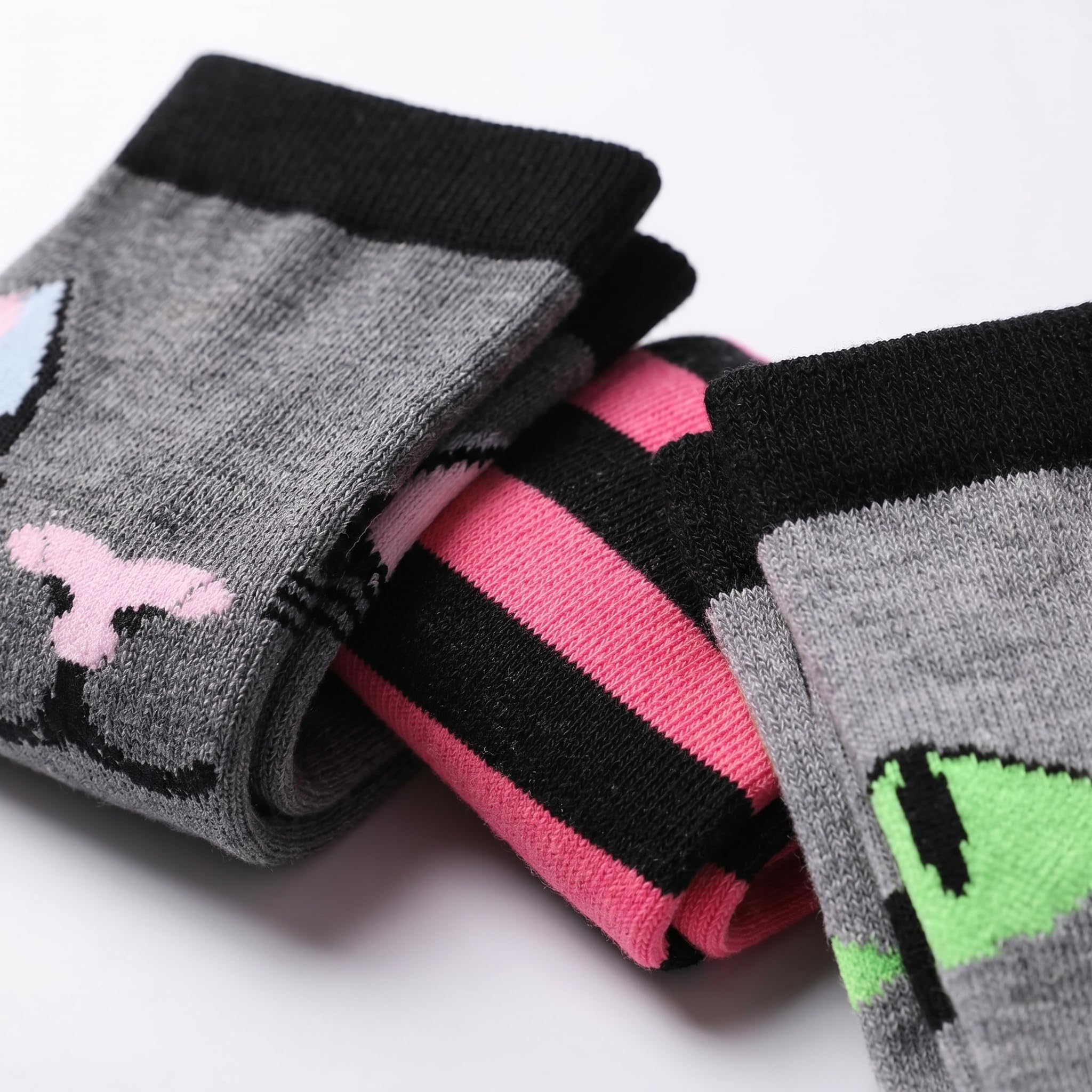 Three pairs of folded crew socks displayed on a white background. The left pair is gray with a black cuff and a pink and black abstract graphic.