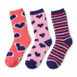 Three pairs of fuzzy crew socks laid flat on a white background: coral pink with dark purple hearts, light pink with dark purple hearts, and dark purple with coral and pink stripes.