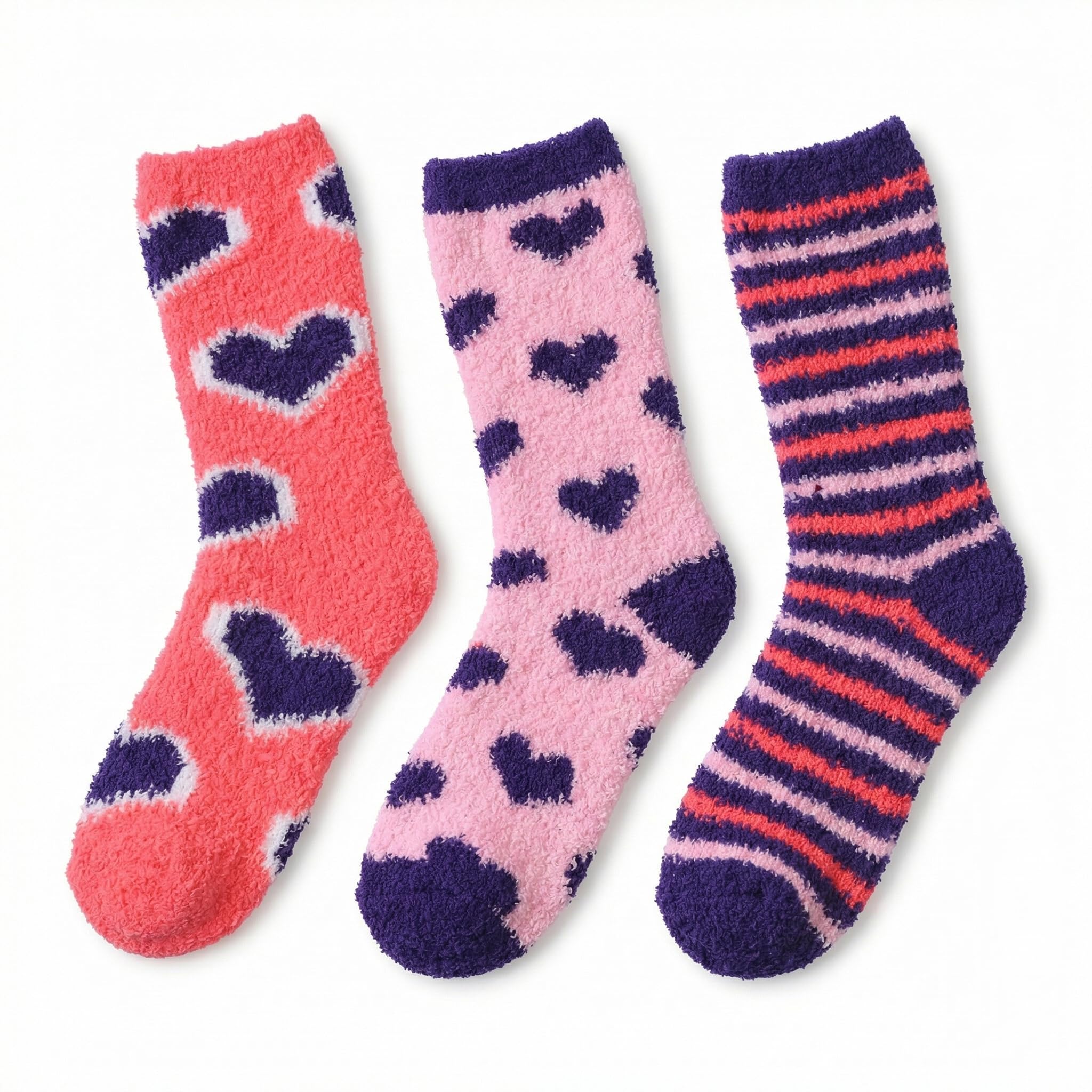 Three pairs of fuzzy crew socks laid flat on a white background: coral pink with dark purple hearts, light pink with dark purple hearts, and dark purple with coral and pink stripes.