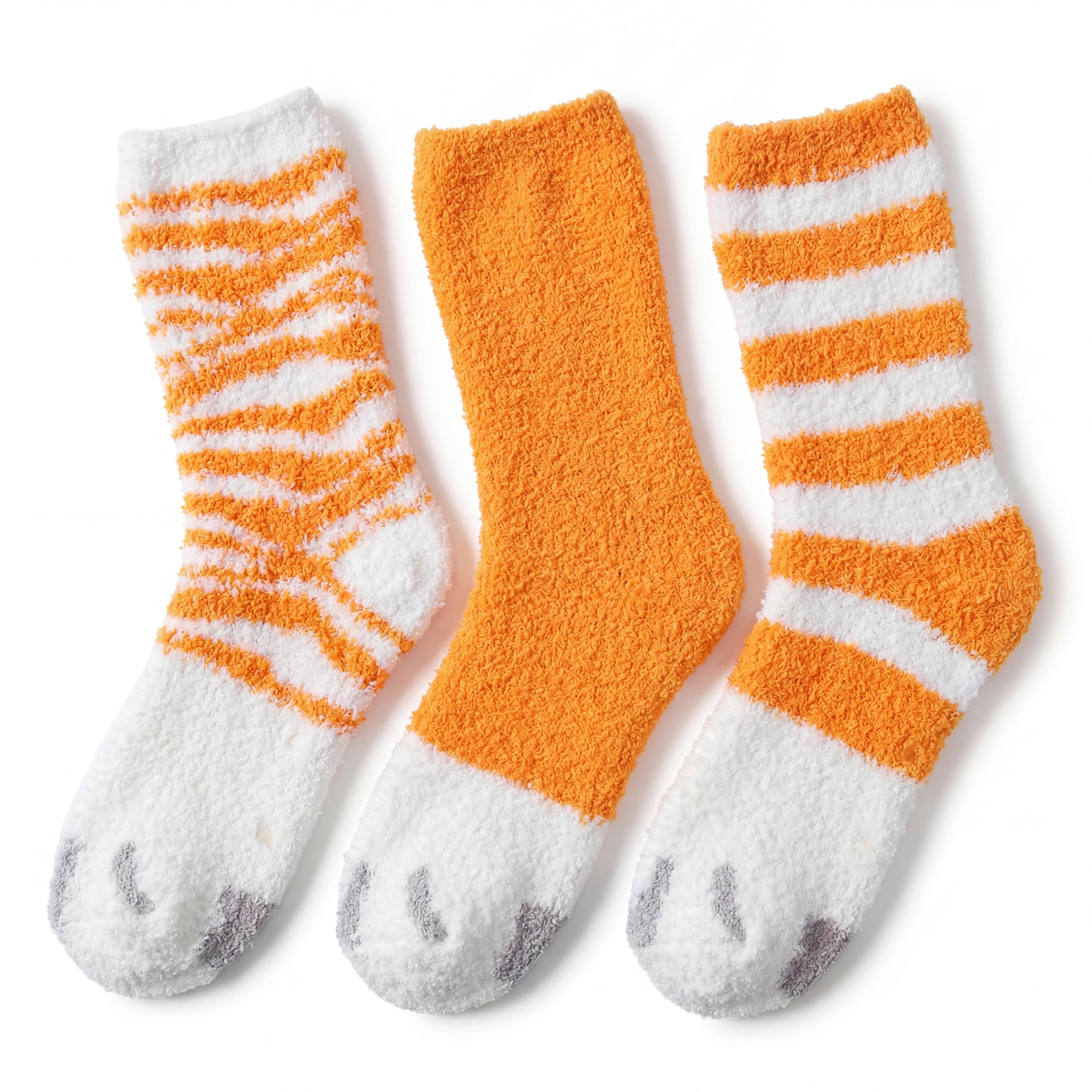 Three plush crew socks in orange and white, arranged side by side on a clean white background. Two socks feature orange and white horizontal stripes, and the center sock is solid orange.