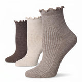 Three ribbed ankle socks with ruffled edges shown in a staggered lineup on a white background. The colors are taupe, cream, and dark brown.