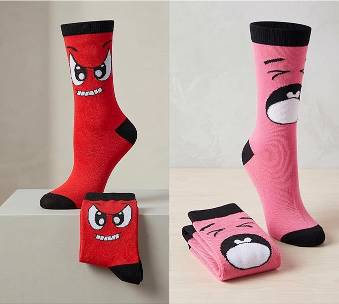 Two pairs of socks with cartoon face designs on a neutral background