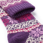 A close-up of a knit sock with a Fair Isle pattern in purple, pink, and cream, folded to show the ribbed cuff and toe area against a white background.