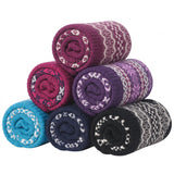 Six rolled knit blankets in assorted colors, including purple, pink, blue, navy, and black, each featuring a white Fair Isle pattern, arranged in a pyramid on a white background.