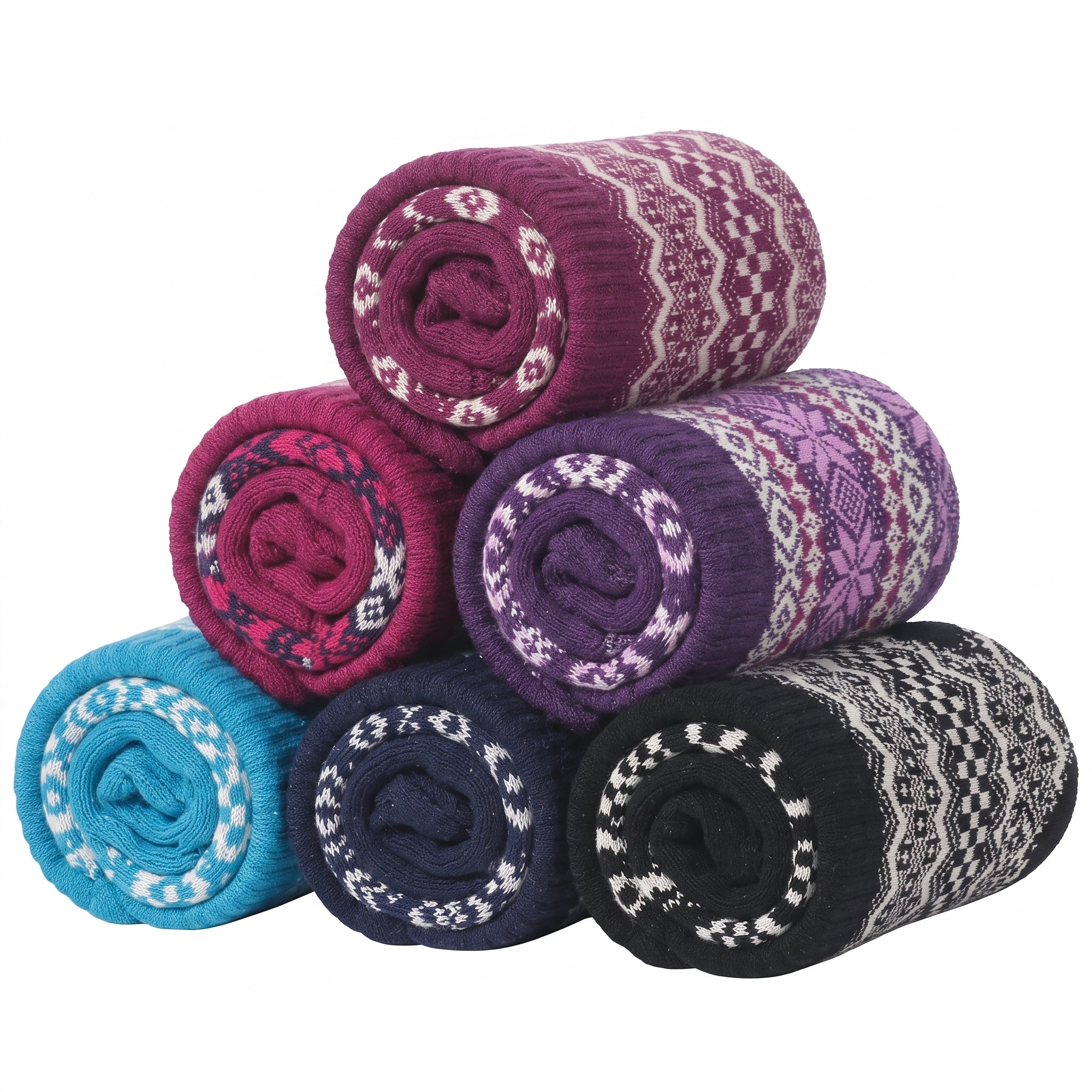 Six rolled knit blankets in assorted colors, including purple, pink, blue, navy, and black, each featuring a white Fair Isle pattern, arranged in a pyramid on a white background.