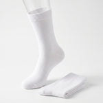 A pair of plain white crew socks, with one sock displayed on a clear mannequin foot and the other folded neatly beside it, set against a seamless white studio background.